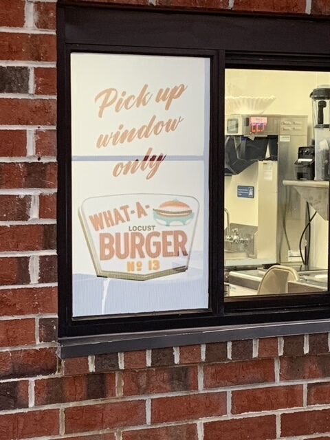 A Sliding Window With What a Burger Sign